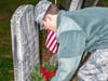 Cadet Tech Sergeant Erik Hanson places a remembrance wreath on a veterans headstone in Raymond Hill Cemetery on Wreaths Across America Day.