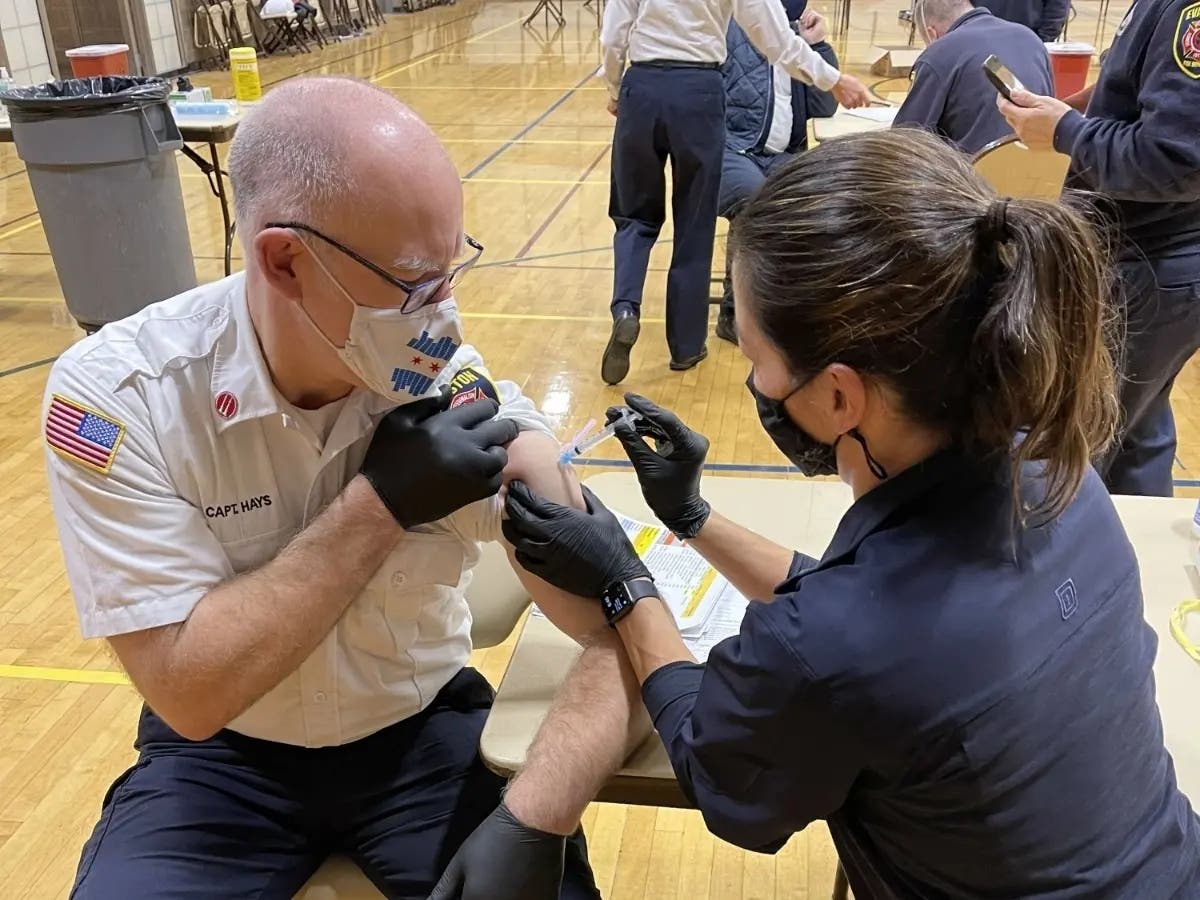 Evanston firefighters vaccinate each other in January before administering doses to residents during the city's vaccine clinics at the Levy Center. 