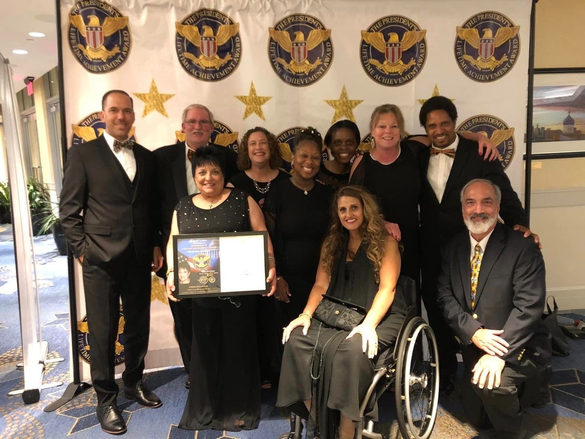 Celebrating with Teresa, who is holding the framed award certificate, were (left to right rear row) Matt Harper, Peter Daly, Jessica Chenery, Latrease Brown, Alicia Morgan, Robin Hansen, Jerry Williams and (front row) Anissa Porticelli and Drew Crandall