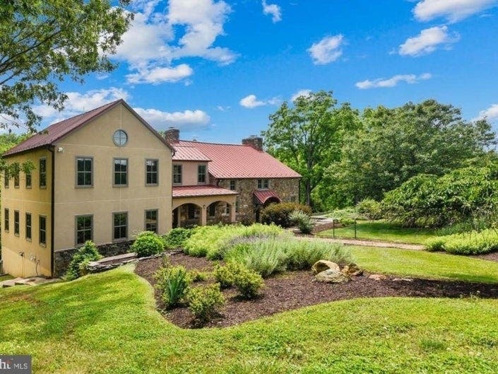 This home near Leesburg comes with a main house, along with two barns and mature woods with riding trails.