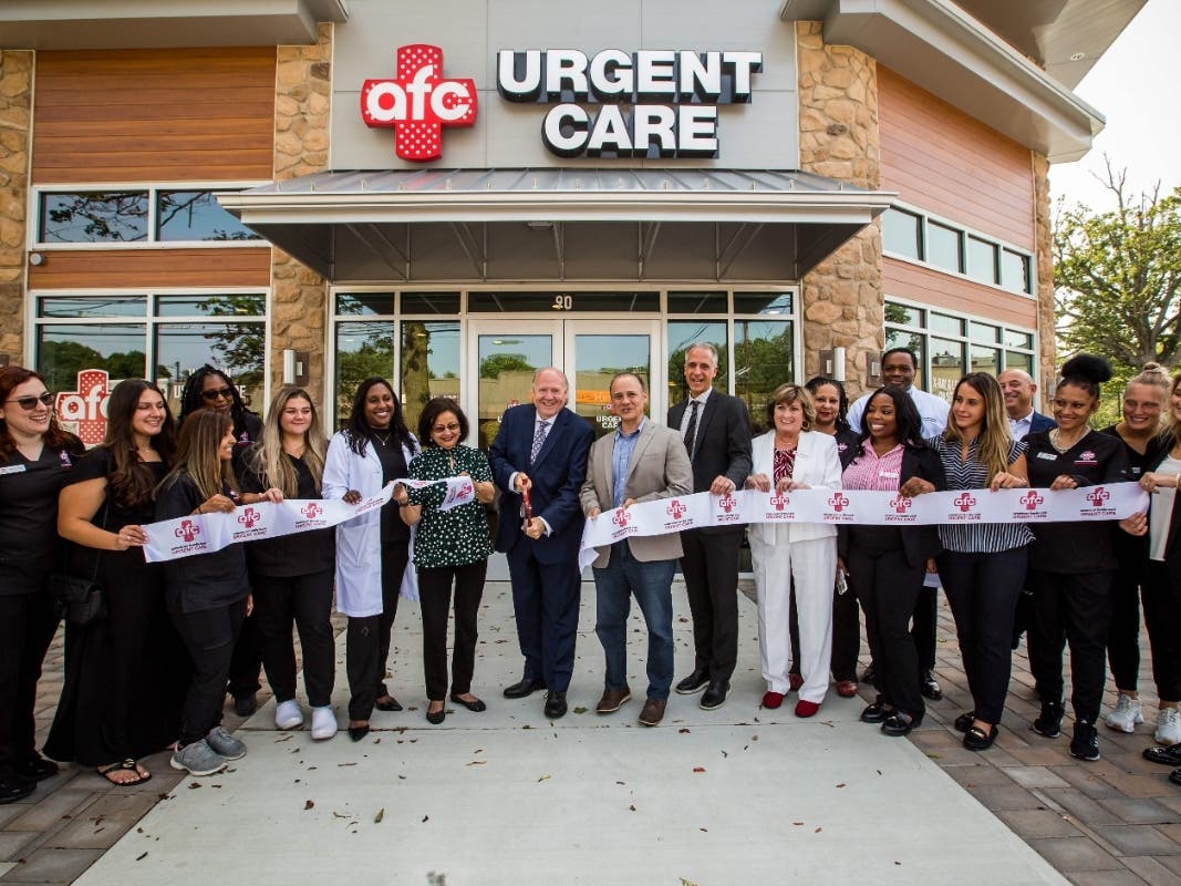 Livingston Mayor Michael Vieira cuts the ribbon for the new AFC Livingston urgent care center with Deputy Mayor Alfred Anthony (to his right), along with AFC leadership and staff, township officials, and regional business leaders.