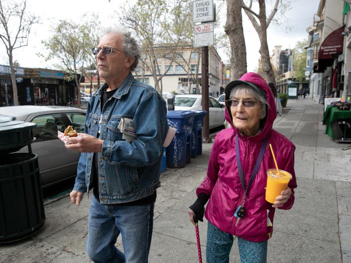 Dolores Helman, 93, and her son Elliot Helman, 64, go for a walk in Berkeley on March 15, 2020, as Gov. Gavin Newsom calls for isolation of all elderly people and those with chronic health conditions in response to growing concern over the coronavirus. 