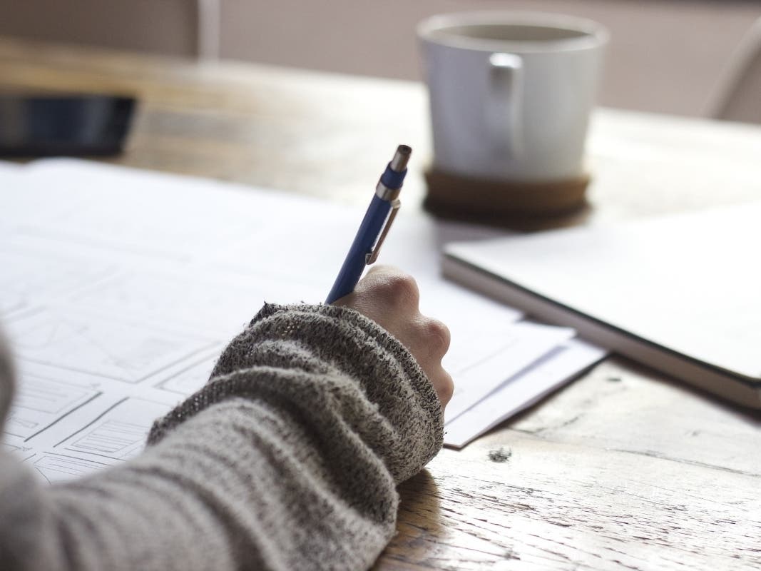 Person with paperwork and a mug