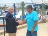 Mayor Chris Alahouzos presents the key to the city to longtime sponge diver Tassos Karistinos.