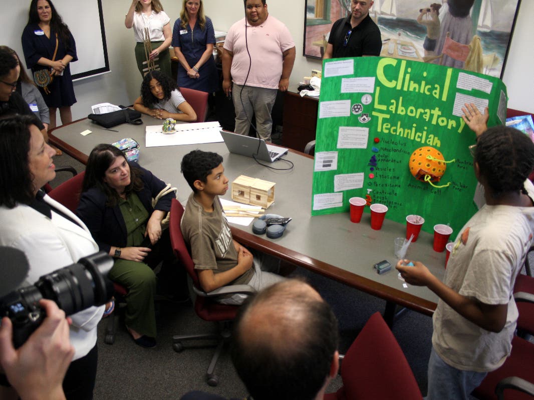 Meutz Moise, a Salem student in LEAP For Education's Summer Work Program, takes Lt. Gov. Kim Driscoll through her project exploring the career path of a clinical laboratory technician during the program's gallery walk at Salem State on Thursday.