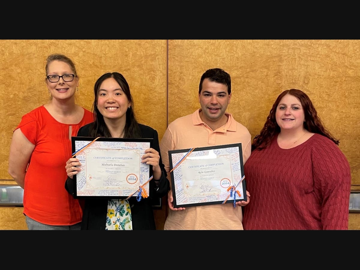 Graduating interns Michaela Donelan and Kyle Gonzalez pose with program administrators. (Not pictured is graduating intern Zyren Collins.)