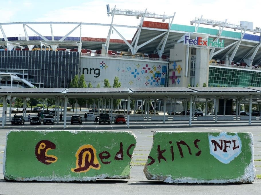 Hand-painted concrete barriers stand in the parking lot of FedEx Field, home of the NFL's Washington Football Team on July 13.