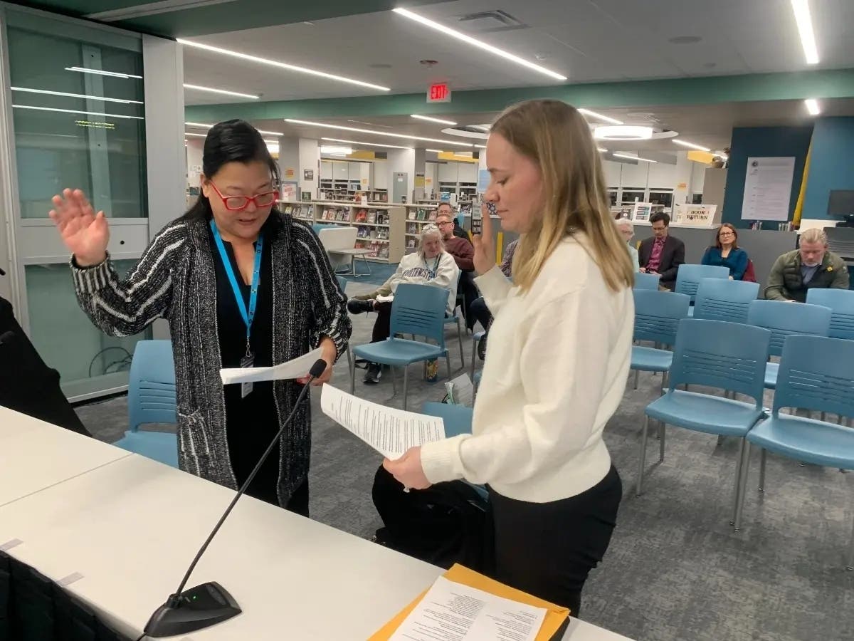 Catherine Greenspon (left), president of the Hinsdale High School District 86 board, swears in Heather Kartsounes as a new board member in December. 