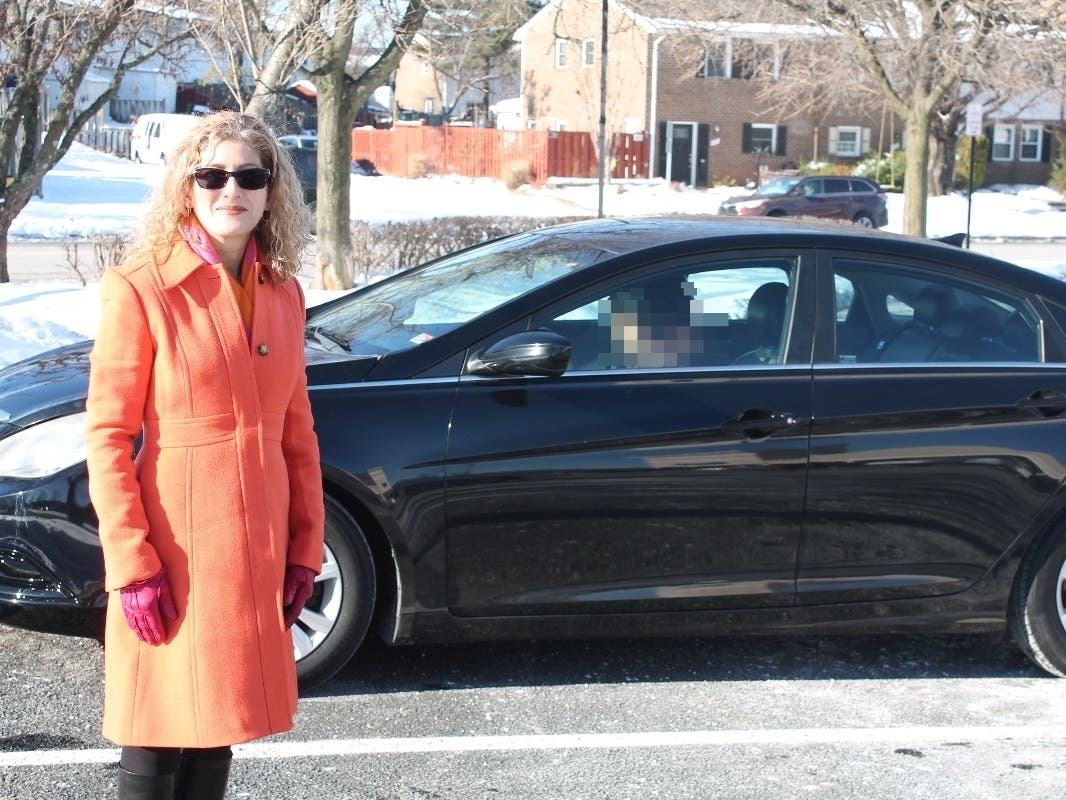 Rides for Refugees president Jacqui Olkin stands by while car recipient Mohamed starts his new car. His face is blurred to protect family members still in Afghanistan.