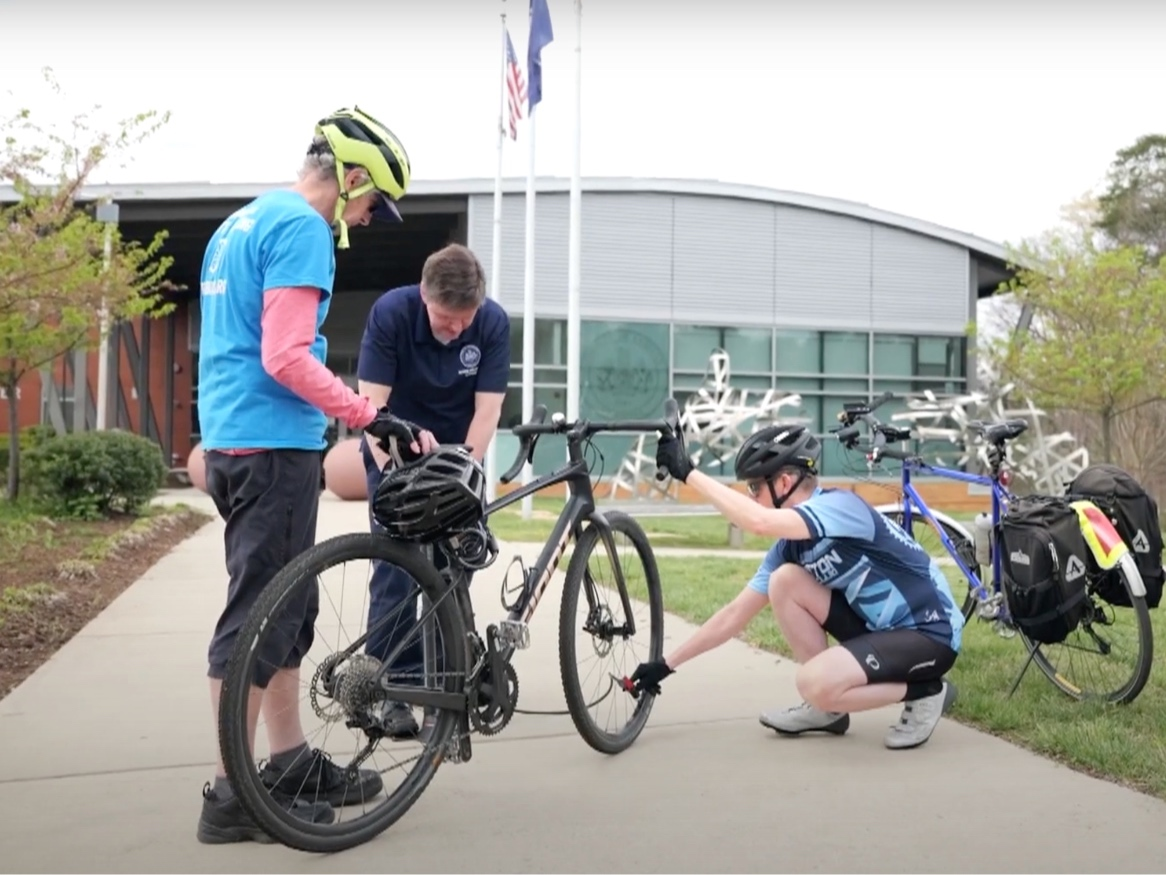 Supervisor Walter Alcorn gets prepares for the 2024 Tour de Hunter Mill with the assistance of Bruce Wright of the Fairfax Alliance for Better Bicycling and Joel Kuester of the Reston Bike Club.