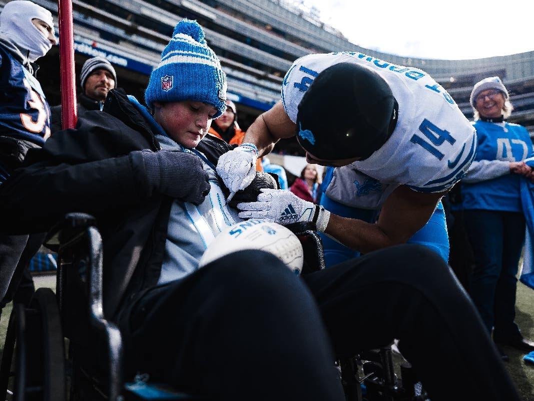 Lions' wide receiver Amon-Ra St. Brown signs a jersey for Illinois teenager Lucas Gidelski before the Lions' come-from-behind victory over the Chicago Bears at Soldier Field.