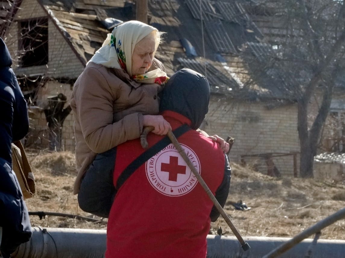 A Red Cross worker carries an elderly woman Friday, March 11, during an evacuation in Irpin, Ukraine, about 16 miles northwest of Kyiv.