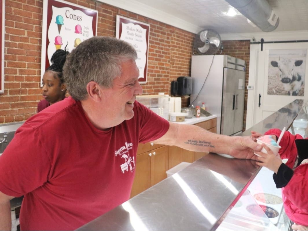 Owner Sveinn Storm serves a frozen treat on March 1, minutes after Storm Brothers Ice Cream Factory reopened from the Annapolis flood.