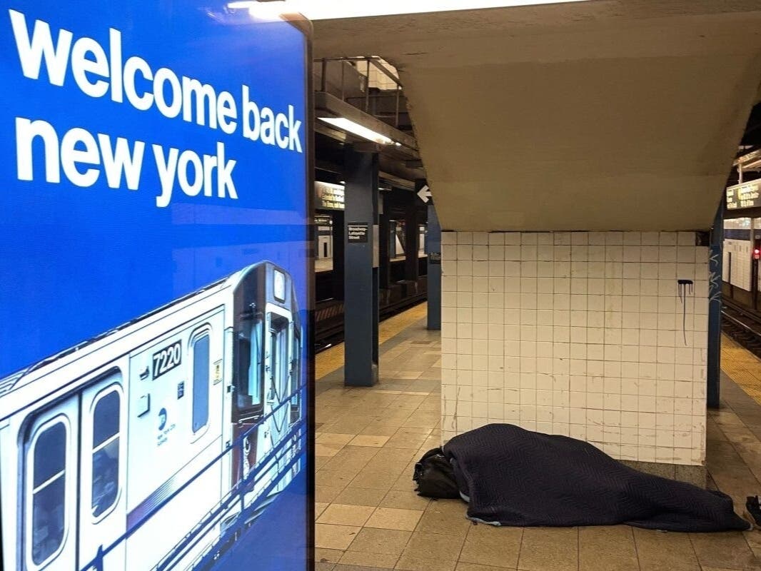 A person sleeps on a subway platform at the Broadway-Lafayette station, Jan. 23, 2022.