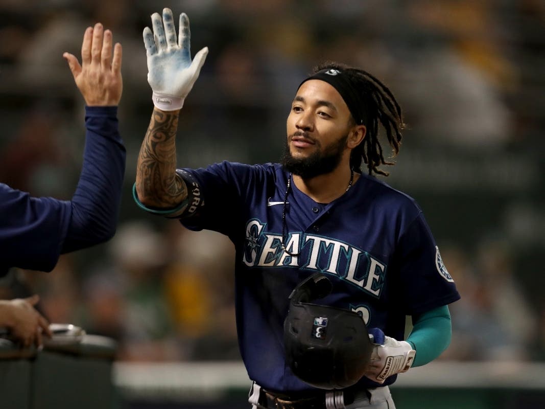 Seattle Mariners' J.P. Crawford is congratulated by teammates after hitting a solo home run against the Oakland Athletics during the eighth inning of a baseball game in Oakland, California, on Sept. 21, 2021.