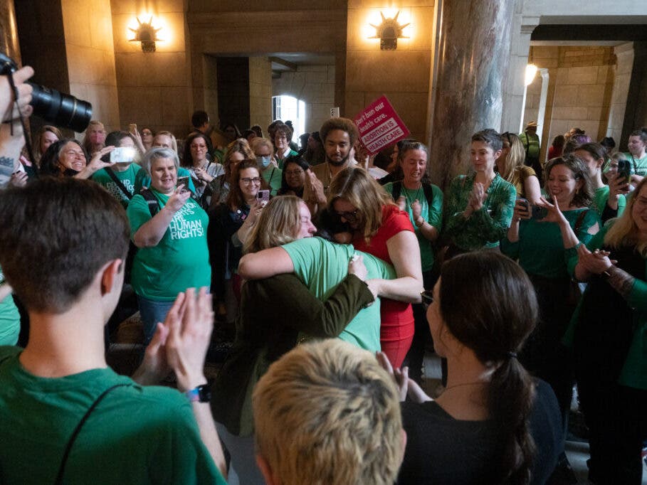 State Sens. Megan Hunt, Jen Day and Machaela Cavanaugh embrace an abortion-rights proponent after a bill to further restrict abortion is defeated on Thursday, April 27, 2023, in Lincoln, Neb. 