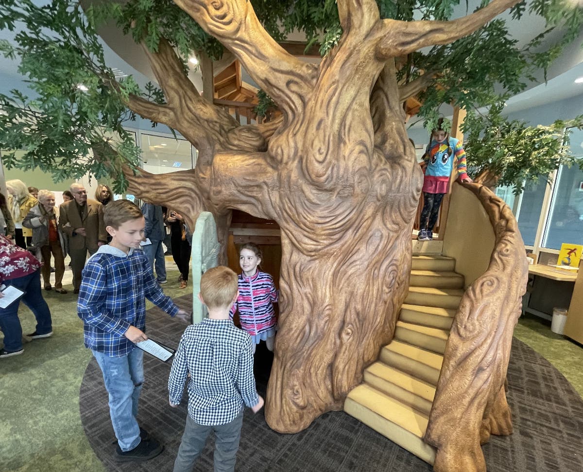 Youngsters explore a tree house inside the Goble Library.