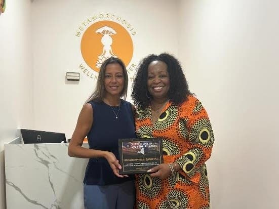 Senator Monica R. Martinez, left, presents the New York State Senate Empire Award to Cheryl Mchunguzi, owner of Metamorphosis Wellness Center on July 31.