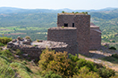 
[image ALT: A photograph of a massive but fairly short two-story stone tower and a short fragmentary stretch of wall, in a countryside of broom and distant vineyards, with a range of low hills in the far background. It serves on this website as the icon for my transcription of the Loeb edition and translation of Aeneas Tacticus.]
		