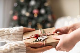 Parent giving a wrapped Christmas gift box to child