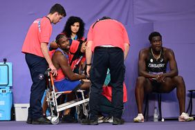 Bronze medallist US' Noah Lyles (C) receives medical attention after competing in the men's 200m final 