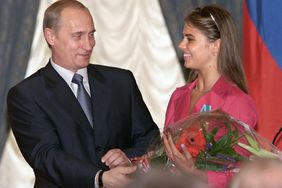 Russian President Vladimir Putin (L) hands flowers to Alina Kabayeva, Russian rhytmic gymnastics star and Olympic prize winner, after awarding her with an Order of Friendship during annual award ceremony in the Kremlin 08 June 2001. AFP PHOTO EPA POOL/SERGEI CHIRIKOV (Photo credit should read SERGEI CHIRIKOV/AFP via Getty Images)