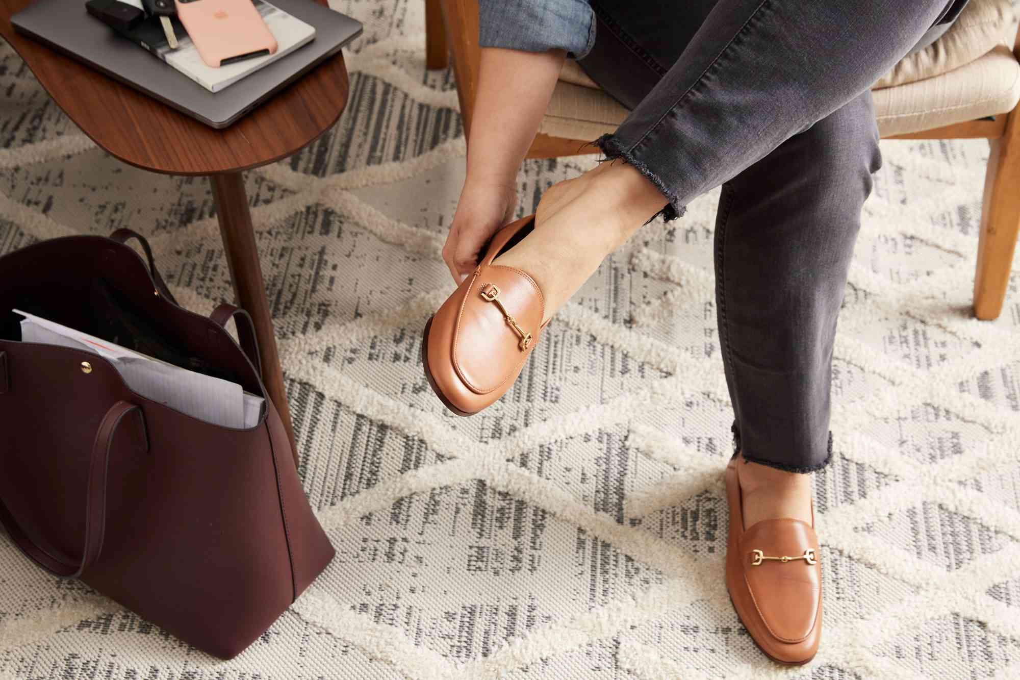 An person sitting to put on Sam Edelman Loraine Bit Loafers 