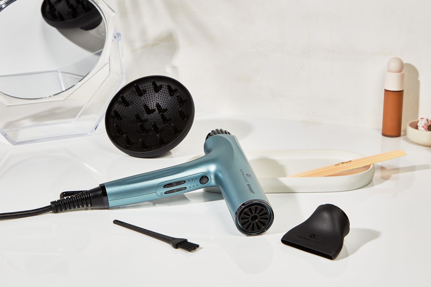 The Olivia Garden High Performance Professional Hair Dryer and accessories on a bathroom counter.