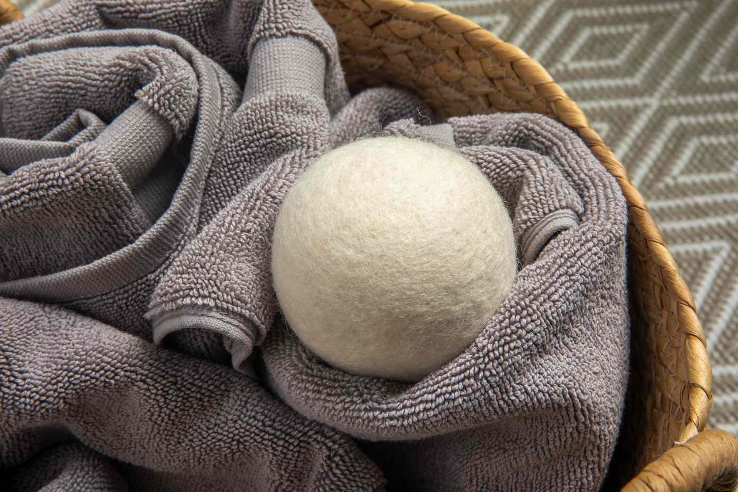 Smart Sheep Dryer Ball displayed on gray towels inside a basket