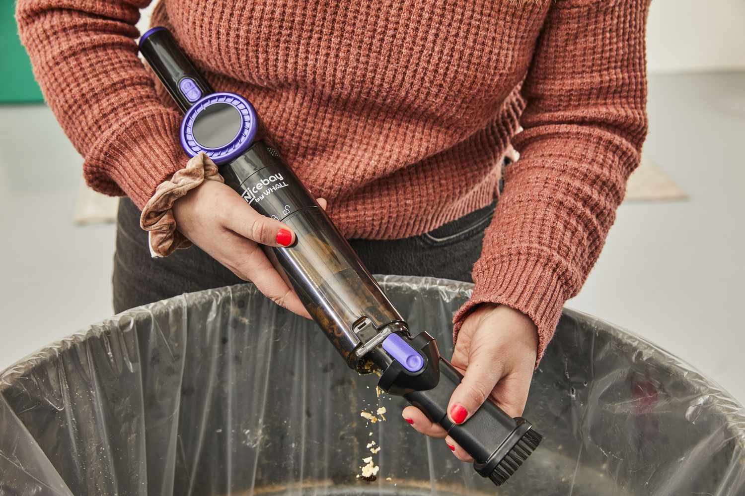 Person emptying Nicebay Handheld Cordless Vacuum into trash