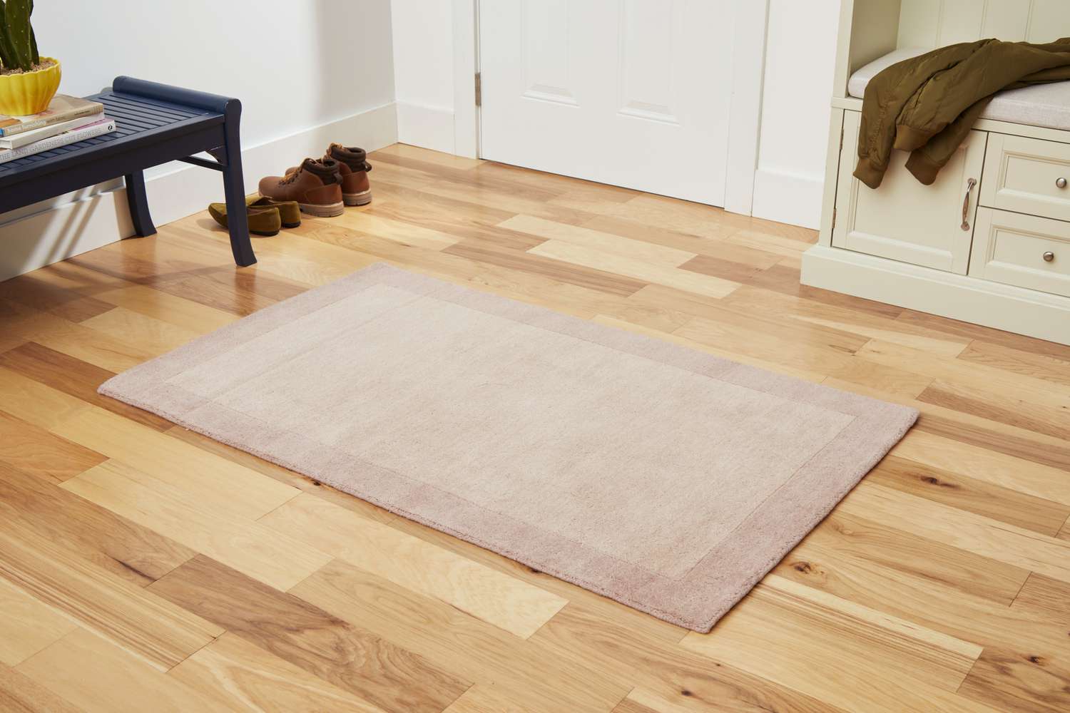 The GreenRow Rhodes Solid Rug on a wood floor