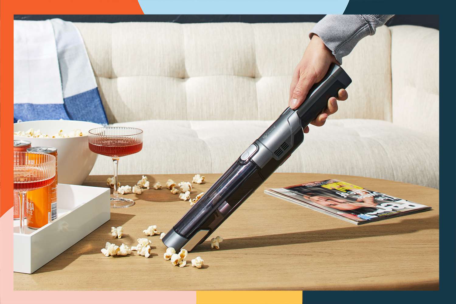 A person vacuuming popcorn with an Iris USA Handheld Vacuum