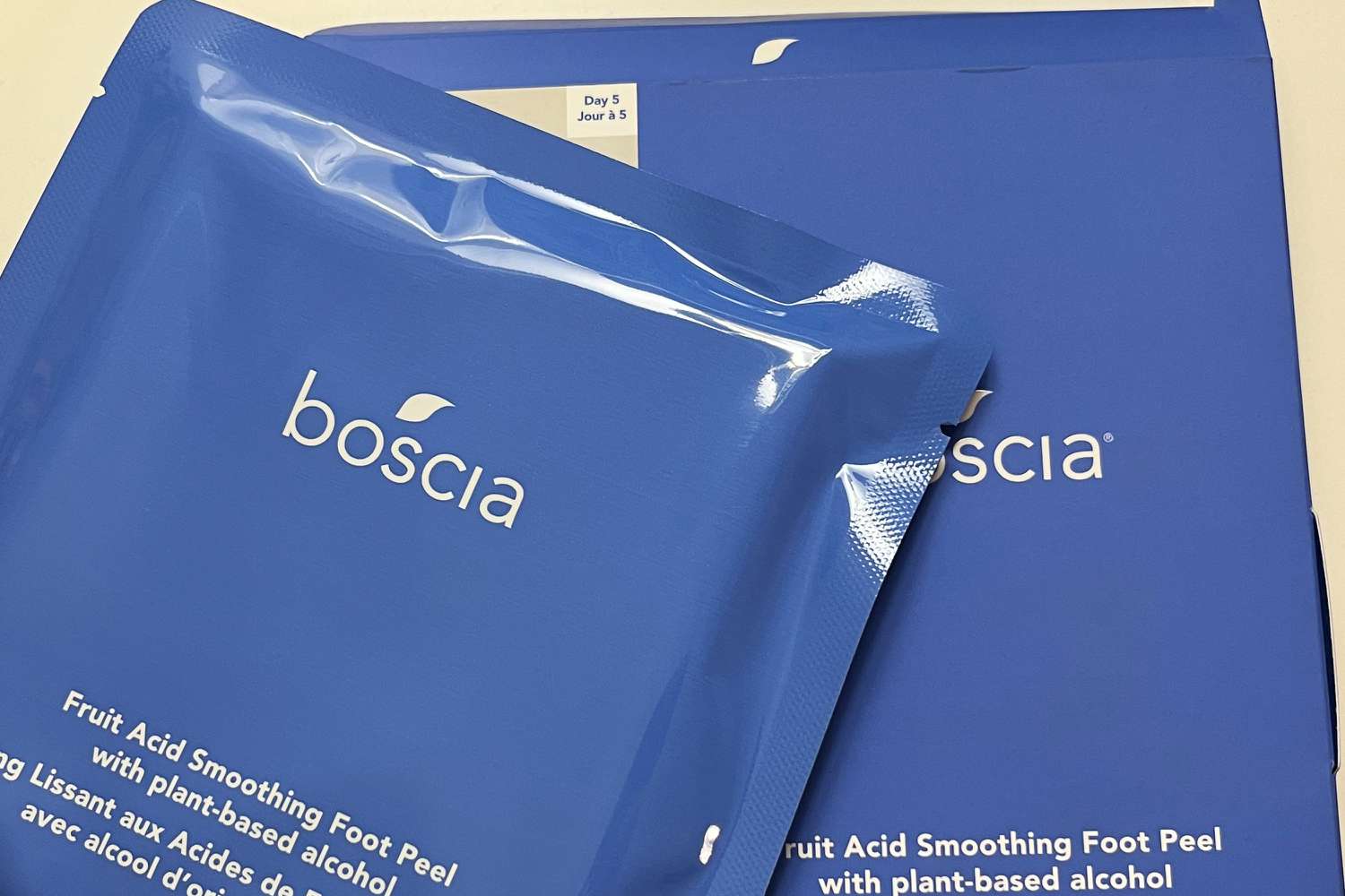 Boscia Fruit Acid Smoothing Foot Peel packaging on bed