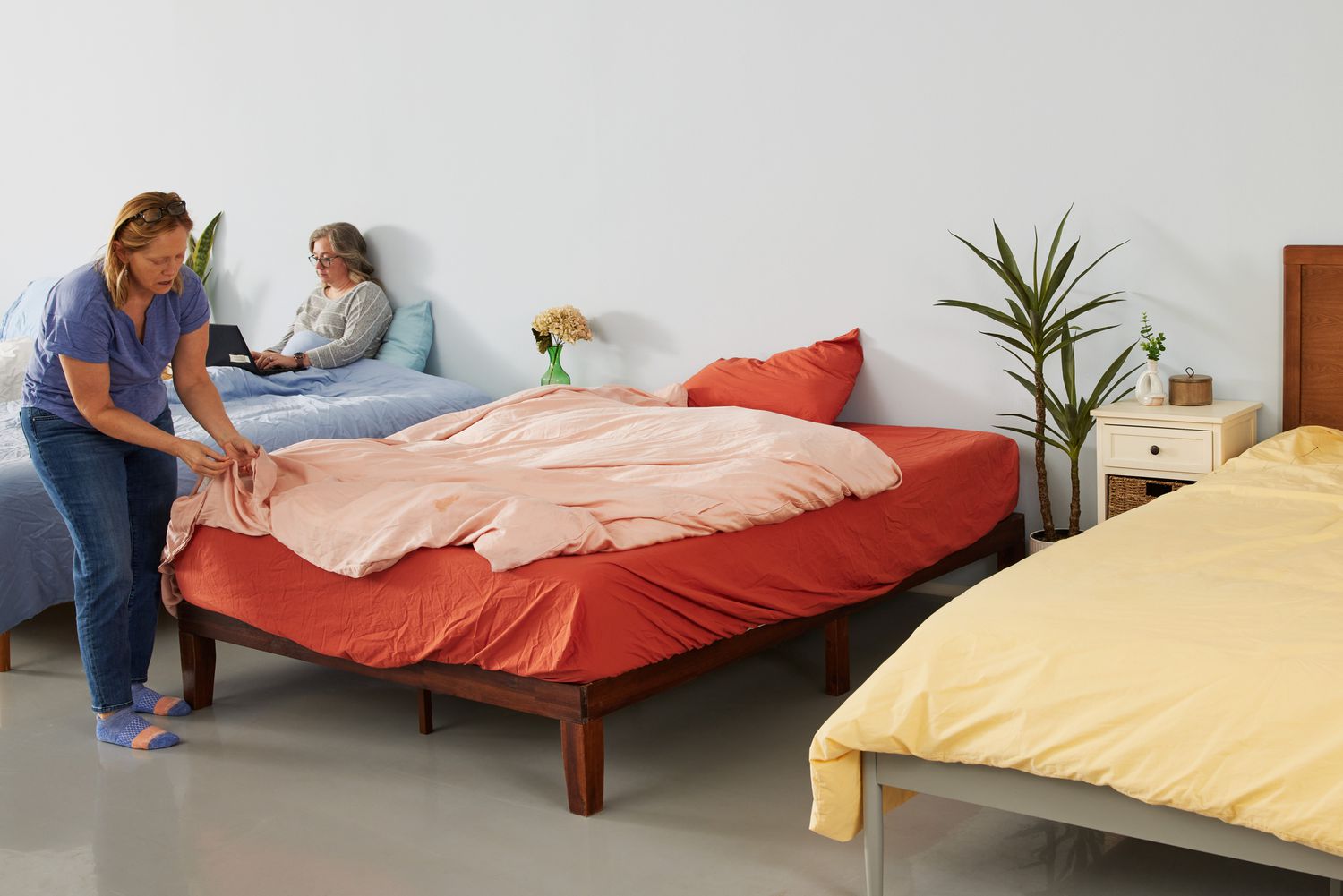 A person fixing a bed with the Eucalypso Heavenly Duvet Cover