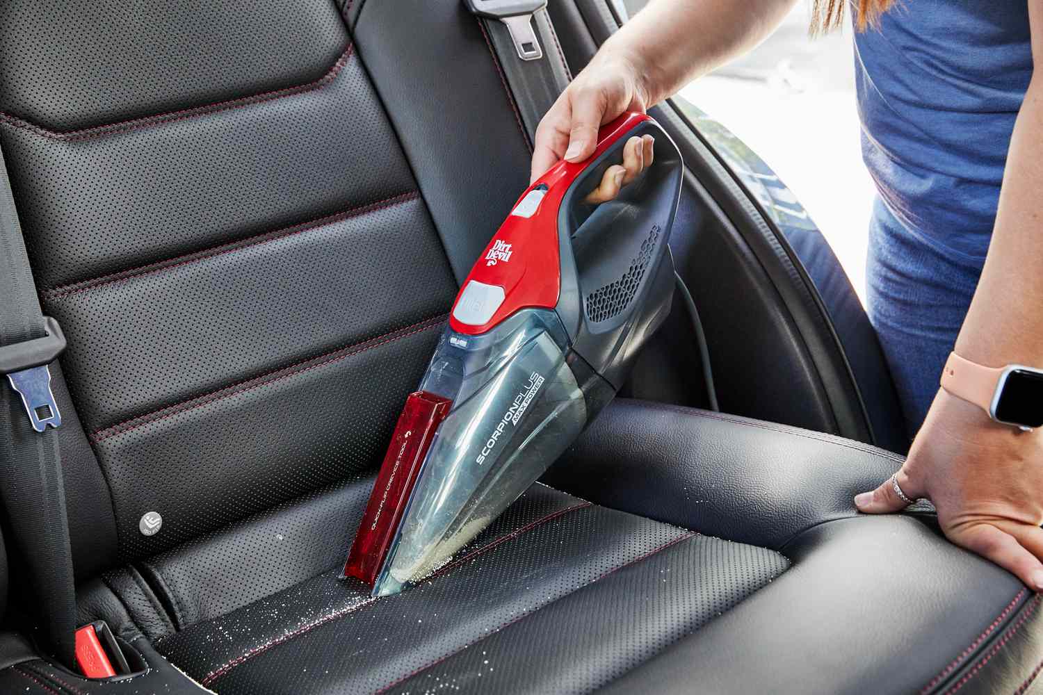 Person vacuuming the seat of a car with the Dirt Devil Scorpion Plus Corded Handheld Vacuum Cleaner