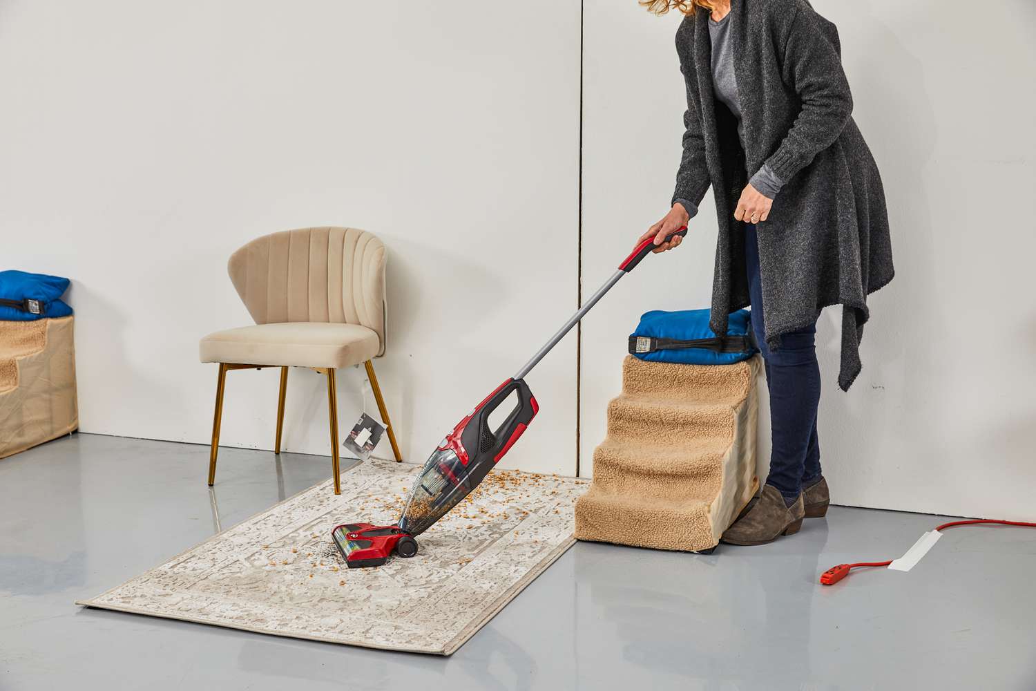 Person vacuuming food from a rug using the DirtDevil Versa Cordless 3-in-1 Stick Vacuum