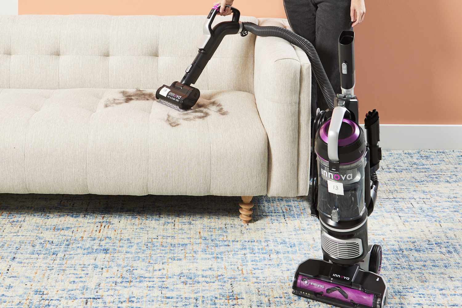 Eureka NEU700 Innova Upright Vacuum is used to clean fuzz on the couch