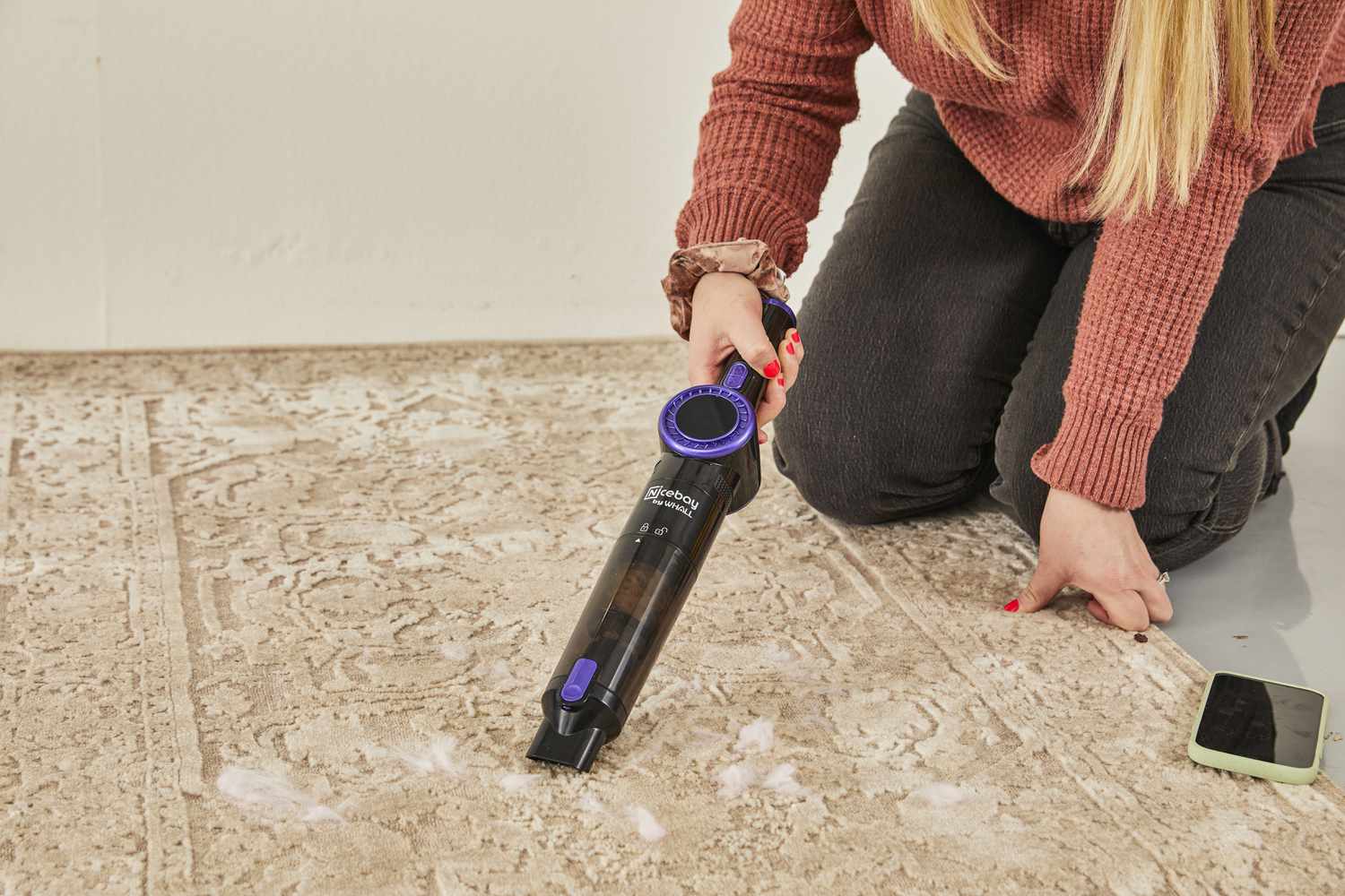 Person using Nicebay Handheld Cordless Vacuum to clean fur from carpet