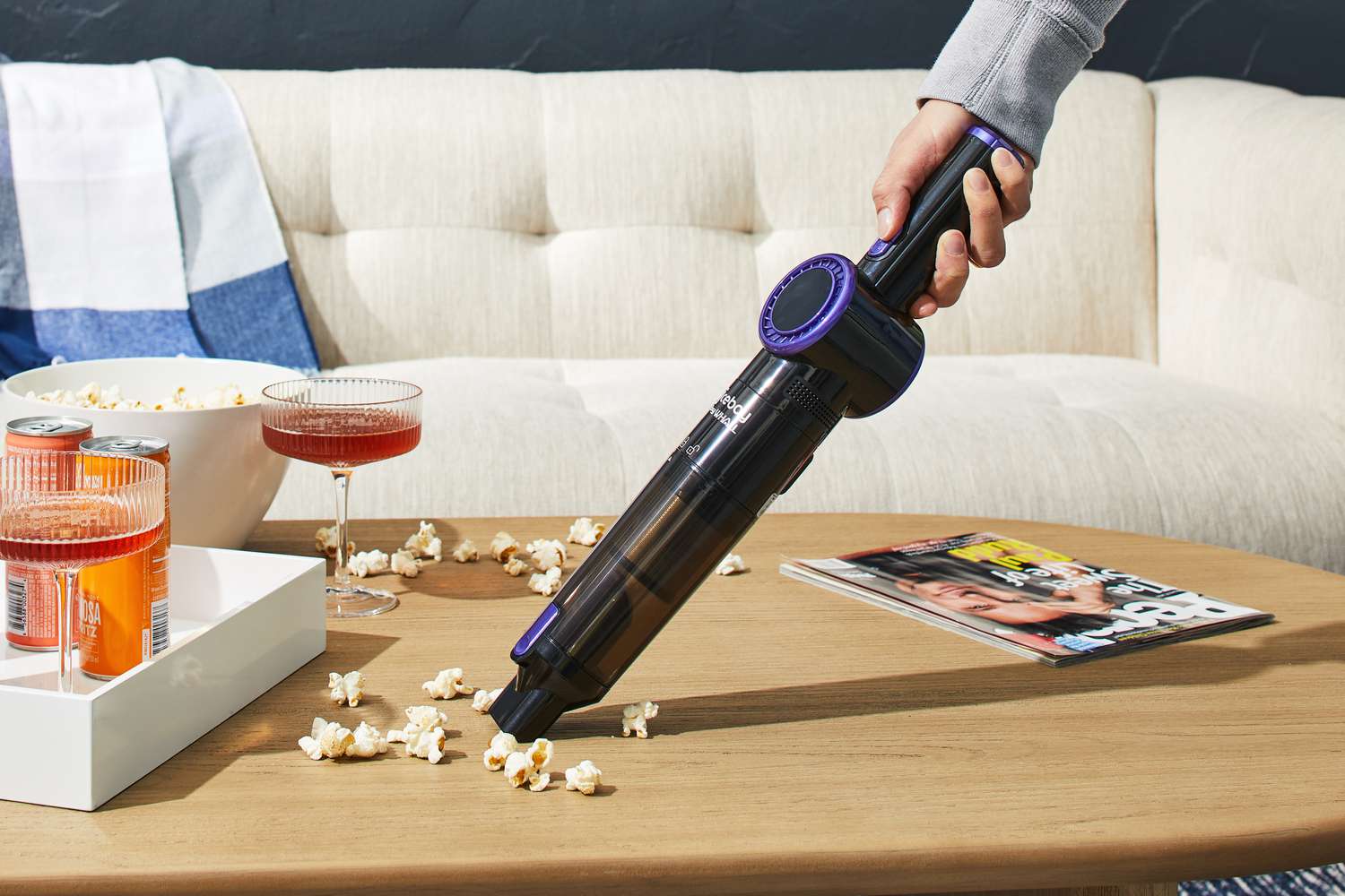 Person using Nicebay Handheld Cordless Vacuum to clean popcorn from table