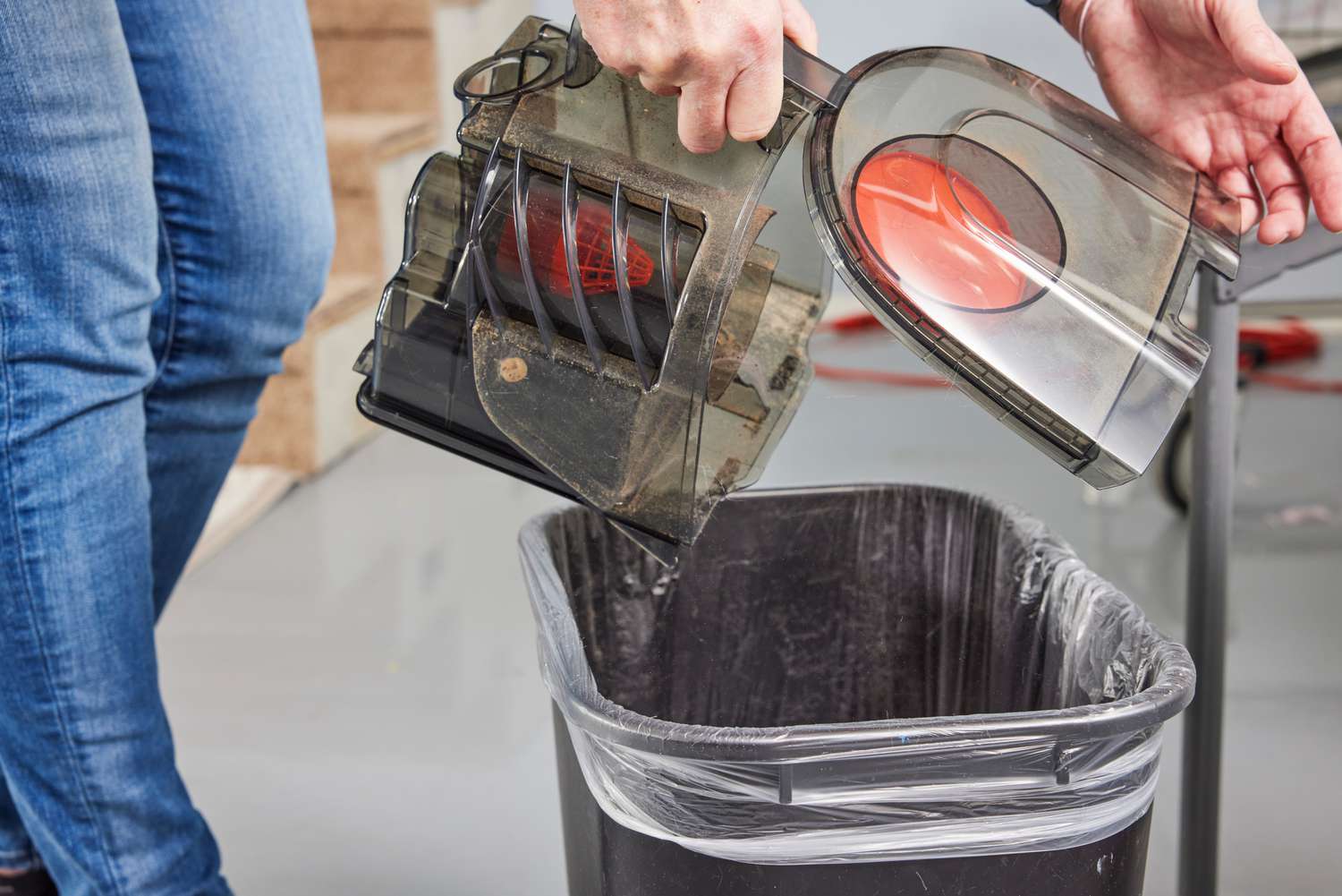 A person empties the Aspiron Canister Vacuum canister