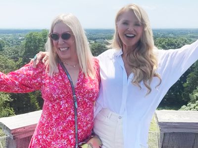 Christie Brinkley poses with friend in white button up top