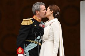 King Frederik X of Denmark and Queen Mary of Denmark (R) kiss on the balcony of Christiansborg Palace in Copenhagen, Denmark 