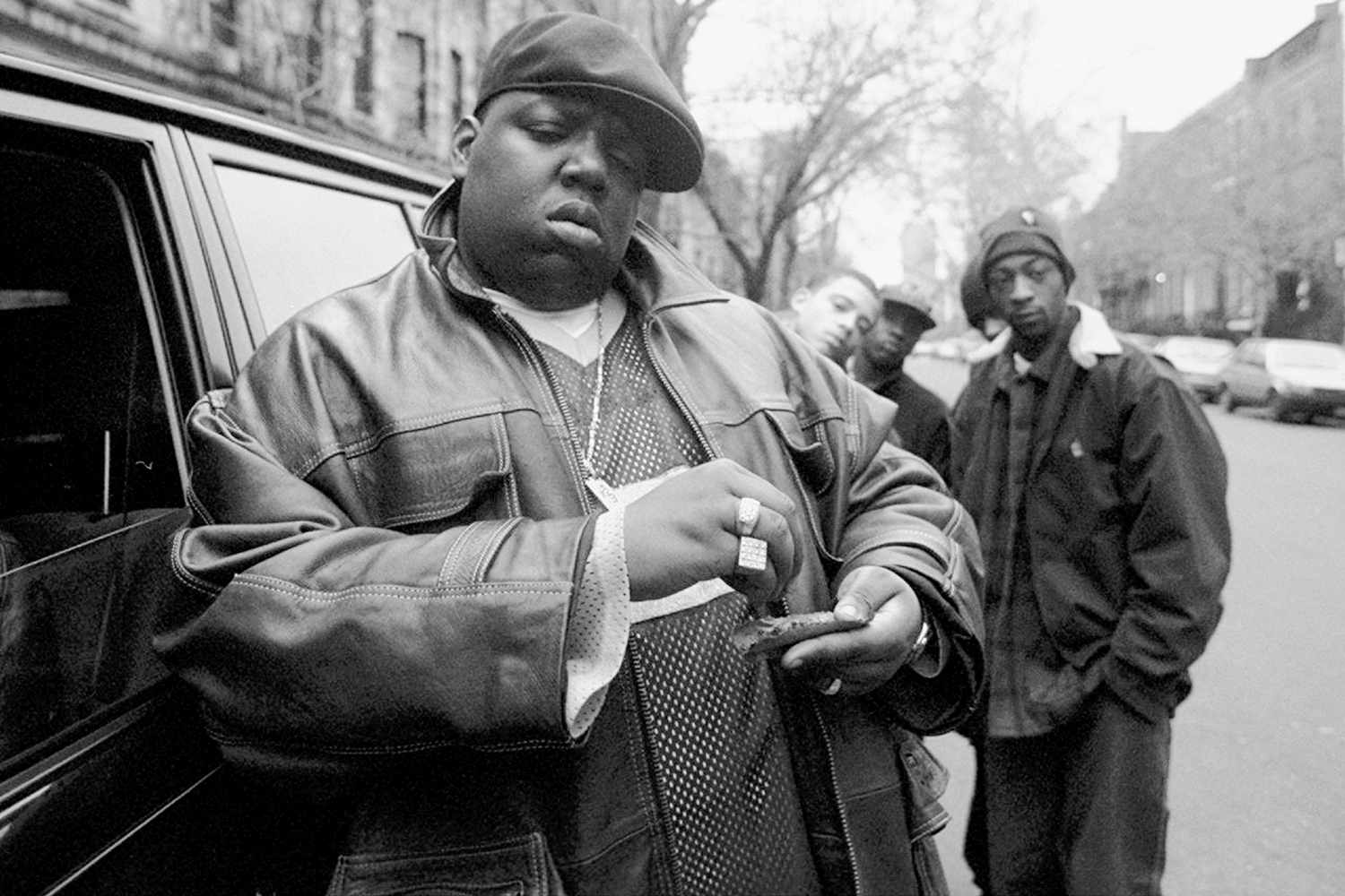 American rapper Notorious B.I.G., aka Biggie Smalls, aka Chris Wallace (1972 - 1997), rolls a cigar outside his mother's house in Brooklyn, New York