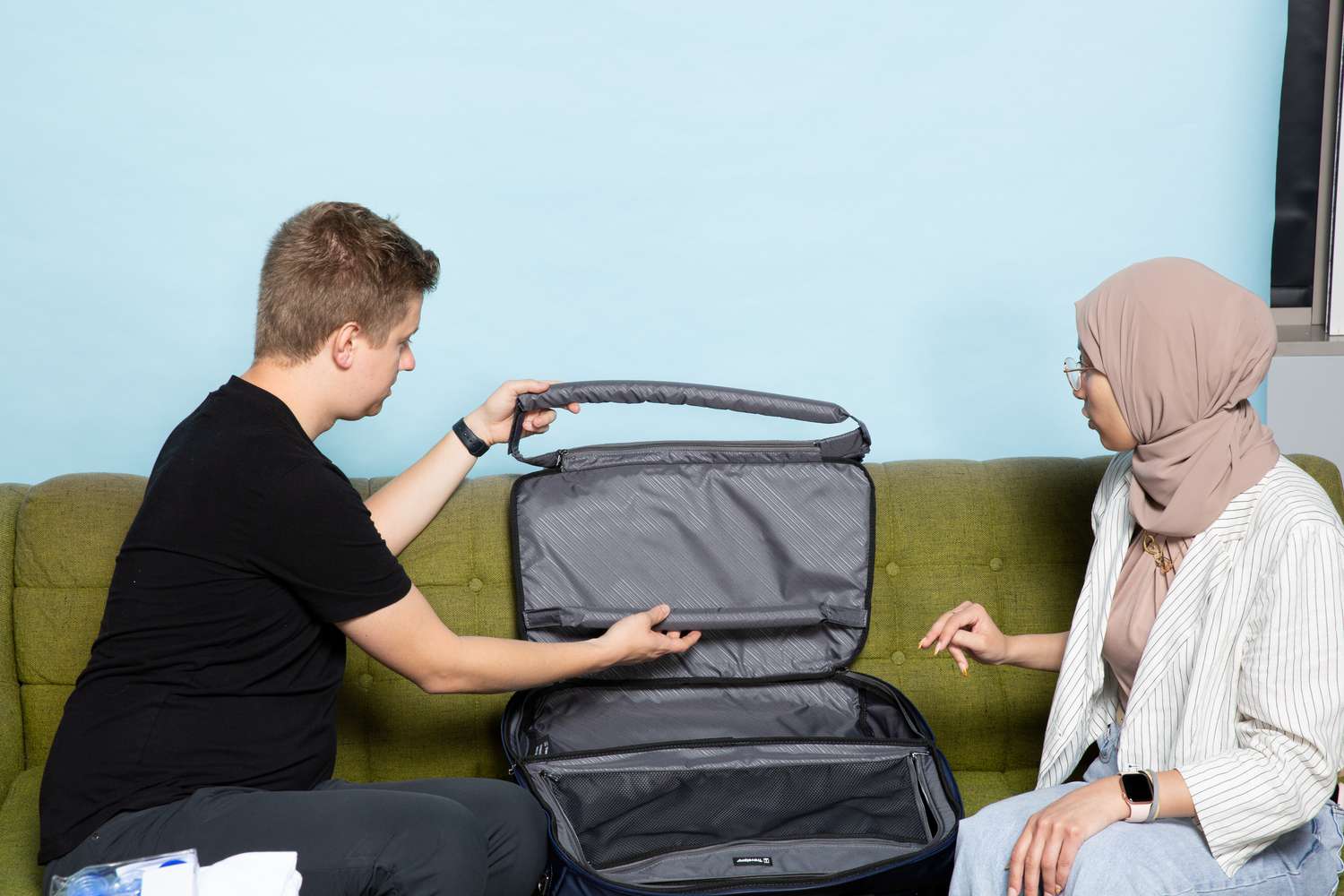 Two people looking at the parts of the TravelPro Crew VersaPack Weekender Bag