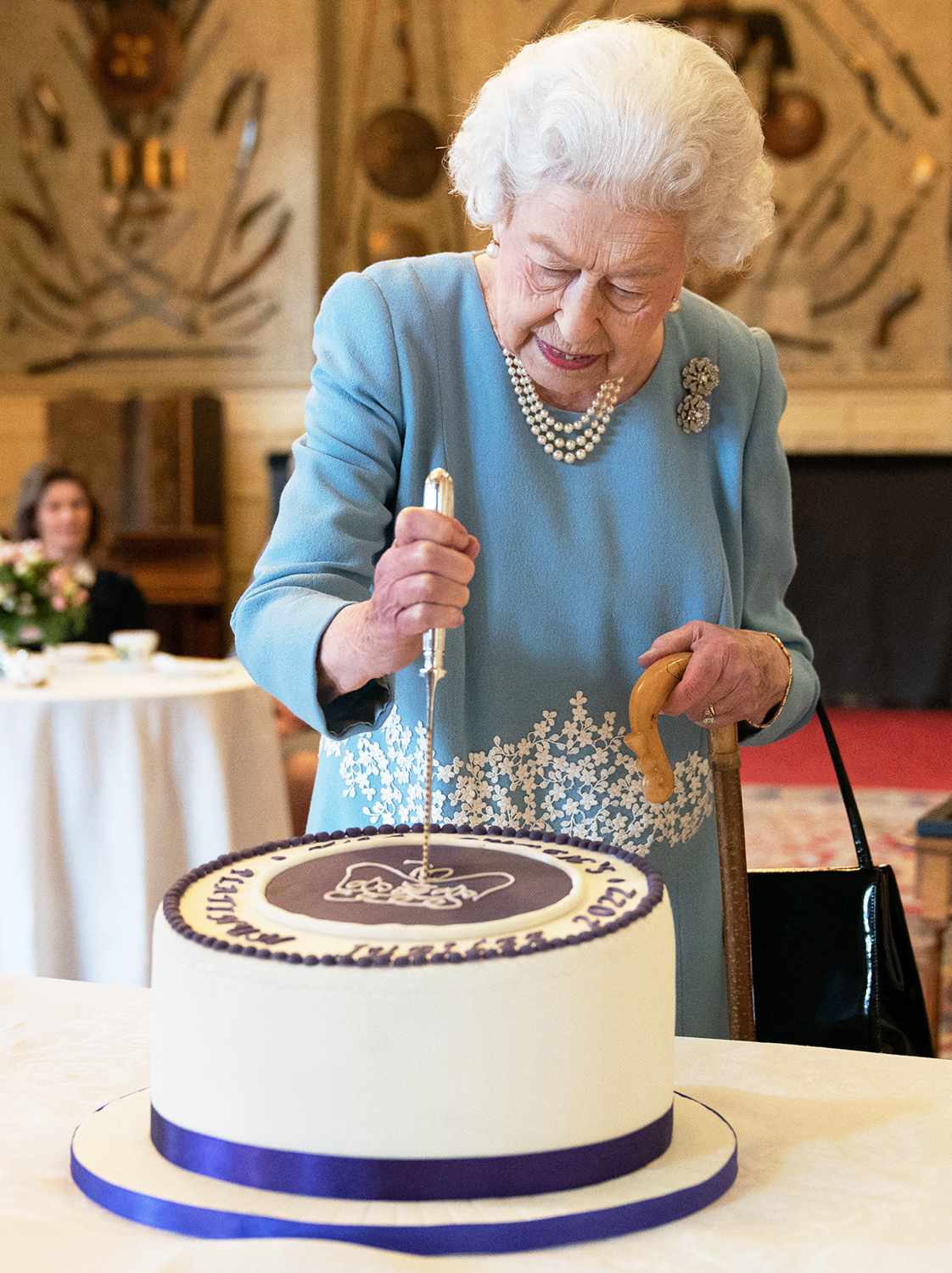 Britain's Queen Elizabeth II cuts a cake to celebrate the start of the Platinum Jubilee during a reception in the Ballroom of Sandringham House, the Queen's Norfolk residence on February 5, 2022.