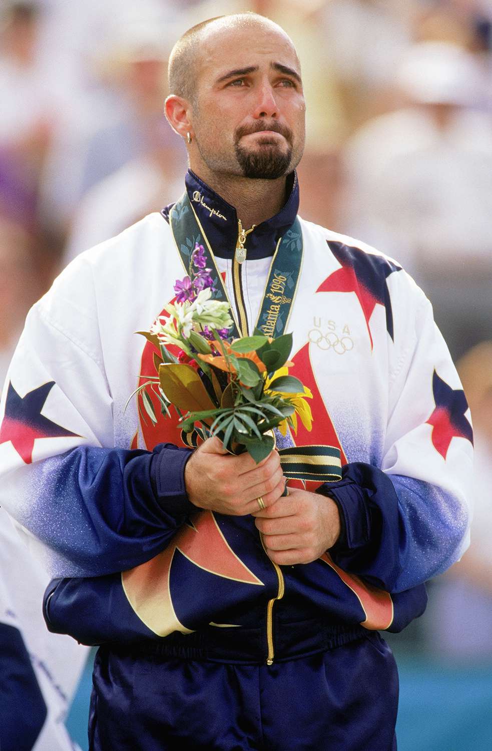 Andre Agassi is full with emotion as he stands as the men's tennis singles gold medal winner during the XXVI Olympic Games at the Stone Mountain Tennis Center on August 3, 1996 in Atlanta, Georgia.