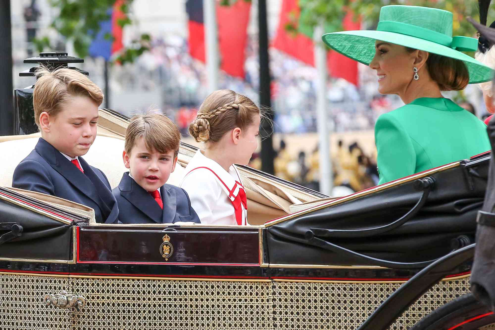 Catherine, Princess of Wales, Prince George, Prince Louis and Princess Charlotte travelling in an open carriage along The Mall in central London