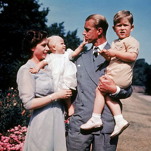 The first color photograph of Princess ANNE, taken in 1951, in the arms of her mother Queen ELIZABETH II while her father, Philip MOUNTBATTEN, holds her brother Prince CHARLES. The family lives at Clarence House, in London.