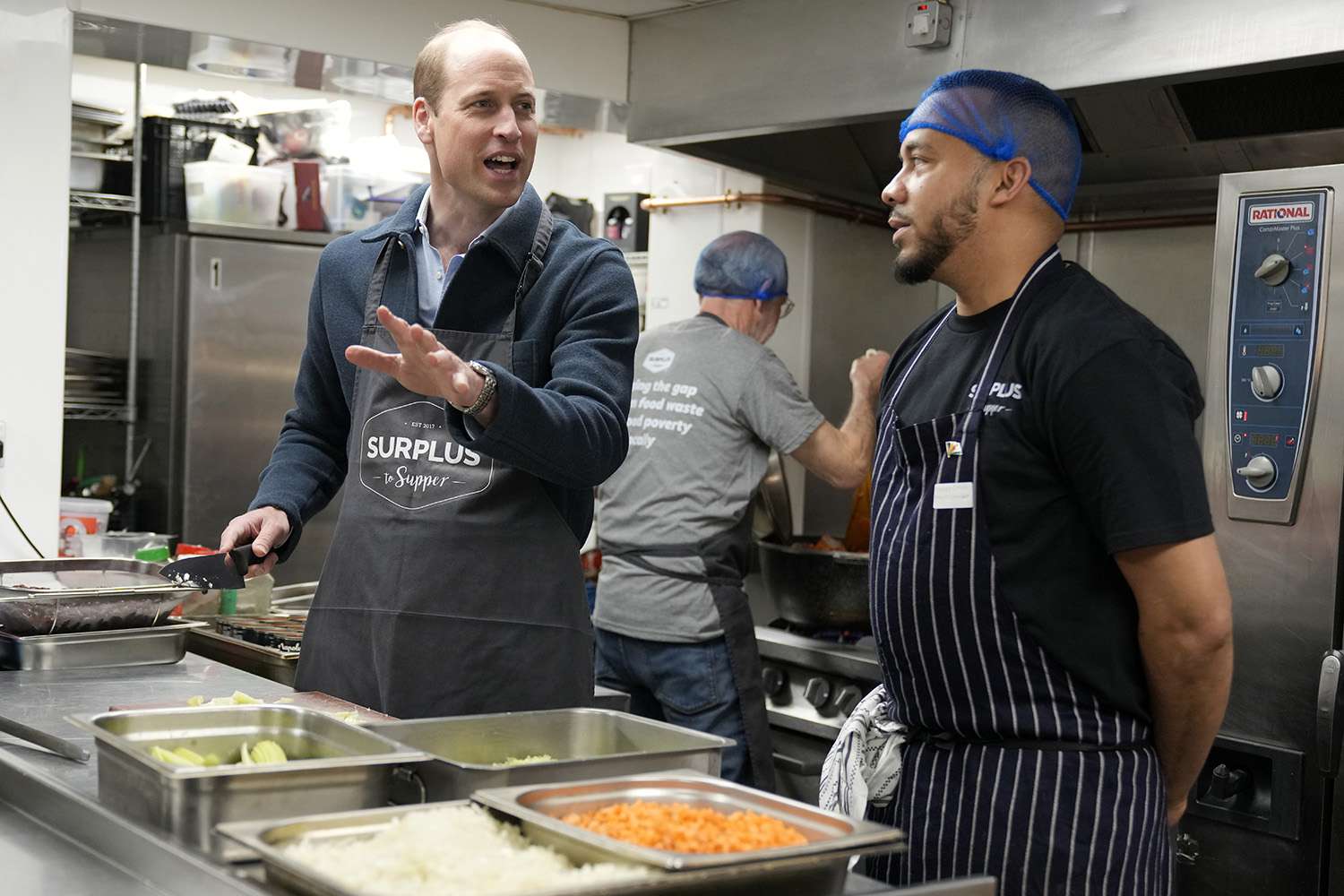 Prince William, Prince of Wales helps make bolognese sauce with head chef Mario Confait, during a visit to Surplus to Supper, in Sunbury-on-Thames on April 18, 2024 in Surrey, England.