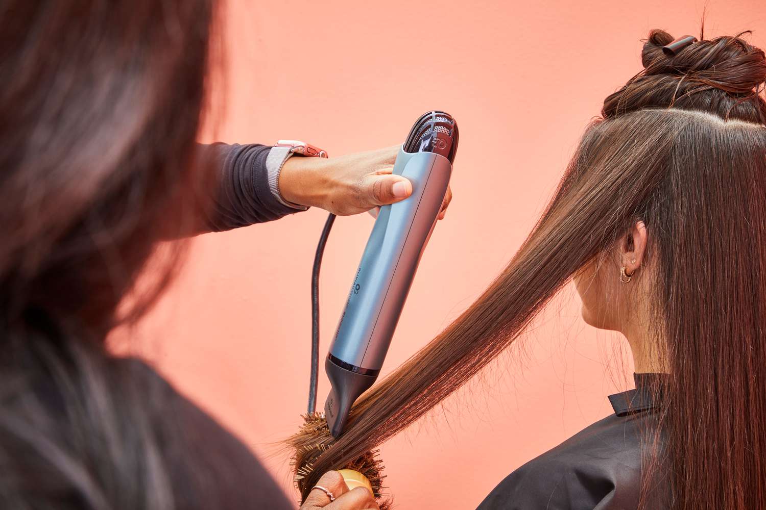 A person using the Olivia Garden High Performance Professional Hair Dryer to dry another person's hair.